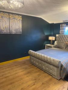 PitseaAlaya's Homes 4 bedroom house的一间卧室配有一张蓝色墙壁的床