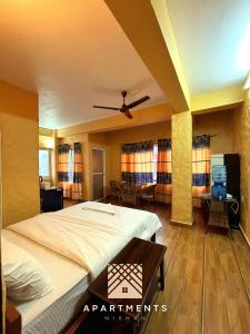 博卡拉Nishan Apartments -Lakeside的卧室配有一张床和一张桌子及椅子