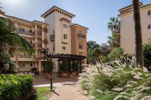 马贝拉Marriott's Marbella Beach Resort的一座带棕榈树庭院的建筑