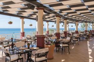 马贝拉Marriott's Marbella Beach Resort的海滩上的餐厅,配有桌椅