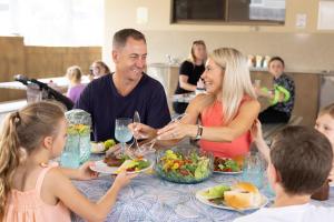 黄金海岸阿什莫尔棕榈度假村的一群坐在桌子旁吃食物的人