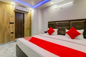 勒克瑙OYO Flagship Hotel Love Inn的一间卧室配有一张带红色枕头的大床