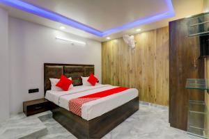 勒克瑙OYO Flagship Hotel Love Inn的一间卧室配有一张带红色枕头的大床