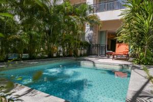 三亚三亚亚龙湾华宇度假酒店的一个带椅子和棕榈树的游泳池