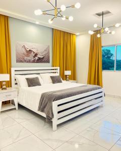 苏莎亚5 Star Villa minutes from Airport and Beaches的卧室配有白色大床和黄色窗帘