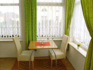 奥门豪斯特Ferienwohnungen Haus Mecklenburg的一间带桌椅和窗户的用餐室