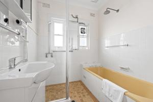 悉尼Cozy Lindfield Stayz的白色的浴室设有浴缸和水槽。