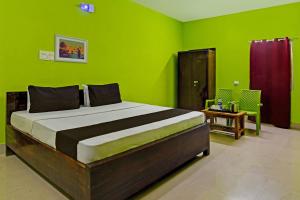 布巴内什瓦尔Khushi Guest House的一间卧室设有一张带绿色墙壁的大床