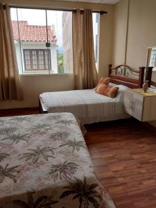 塔里哈Hotel Apartamentos "Dominó"的一间卧室设有两张床和窗户。