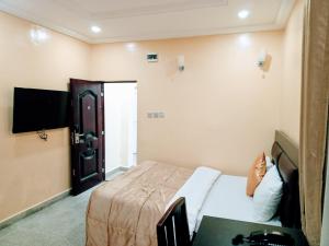 AjaJaiye's Place的一间酒店客房,配有一张床和一台电视