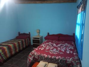 卡奇Casa de familia的一间卧室配有一张红色床罩的床