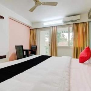 阿勒皮AEC Travel and Leisure Solution Pvt Ltd的卧室配有一张大白色床和红色枕头