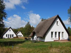 维特Doppelhaushälfte in Vitte auf Hiddensee的两栋白色小屋 - 带自行车停放在田野