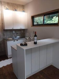 弗洛里亚诺波利斯Chalé da Colina Florianópolis的厨房配有白色橱柜和2个酒杯