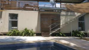 塔尔科莱斯Container home 25 min Jaco y Herradura的一座设有楼梯的建筑,毗邻游泳池