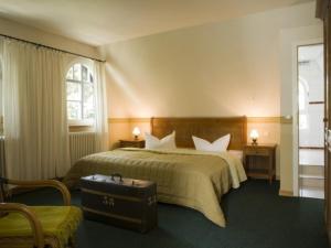 克洛斯特Hotel Hiddensee Hitthim的酒店客房,带一张床和行李箱