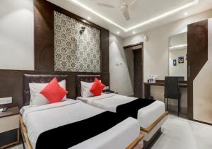 BārhThe Ganga Residency的两张位于酒店客房的床铺,配有红色枕头