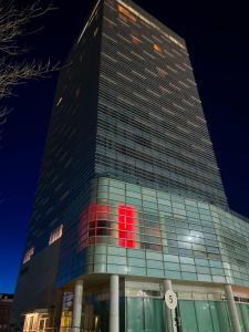 阿特劳Atyrau Executive Apartments的一座高大的建筑,上面有红色的标志