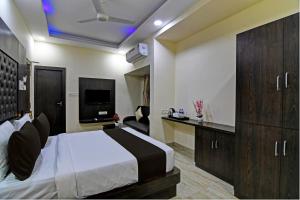 加尔各答Townhouse Hotel Refresh的一间酒店客房,配有一张床和一台电视