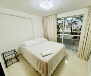 若昂佩索阿Tambaú Home Beira Mar - com varanda的一间卧室设有一张床和一个大窗户