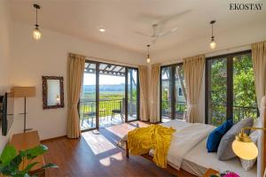 坎多林EKOSTAY Luxe - Jade Villa I Infinity Pool I Paddy Field Views的一间带大床的卧室和一个阳台