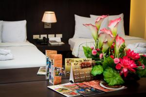 马尼拉塞提特托尔酒店的一间酒店客房,配有鲜花桌