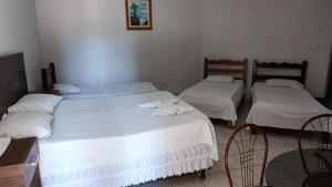 卡塞雷斯Hotel Turazzi的配有白色床单的客房内的两张床