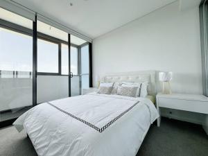 悉尼Modern 2Brs@ close2 Olympic park的白色的卧室设有一张大床和一个窗户