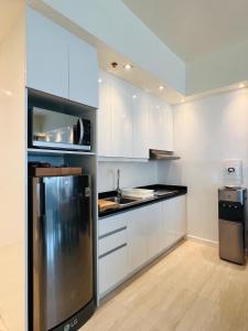 麦克坦Relaxing 1BR Suite in La Mirada的厨房配有白色橱柜和不锈钢冰箱