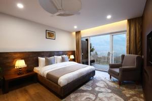 马拉里Kaizen X Voyage Resort And Spa, Manali的卧室配有床、椅子和窗户。
