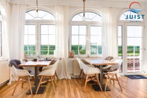 于斯德Pension Marie Luise 252 - Zimmer Venusmuschel的用餐室设有2张桌子和椅子以及窗户。