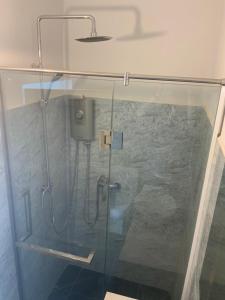 金边Julieka’s Guesthouse的浴室里设有玻璃门淋浴