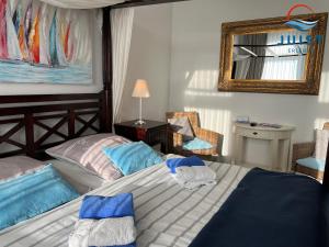 于斯德Pension Marie Luise 255 - Zimmer Kammmuschel的一间卧室配有一张带蓝色枕头和镜子的床