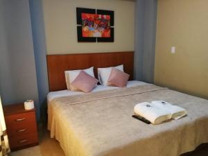 卢那欢纳Hostal Aventura Total Perú_lunahuana的一间卧室配有一张床,上面有两条毛巾