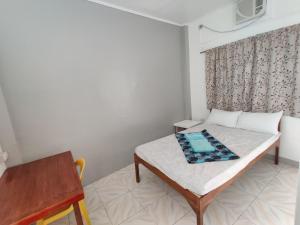 马拉帕斯加Mandurah's Inn, Malapascua的小房间设有一张床和一张桌子