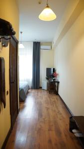 阿拉木图Saraishyq Hotel的客房设有带一张床的卧室,铺有木地板。