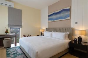 内罗毕Pan Pacific Serviced Suites Nairobi的卧室设有一张白色大床和一扇窗户。
