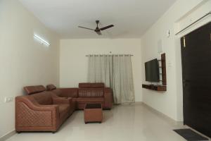 海得拉巴Mee Homes - Madhapur Fully Furnished 2 BHK Flats的客厅配有棕色沙发和电视