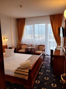 克卢日-纳波卡贝尔维德酒店的酒店客房设有一张床、一张书桌和窗户。