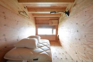 尾道市Guest House Gamigami的卧室配有一张白色的木墙床