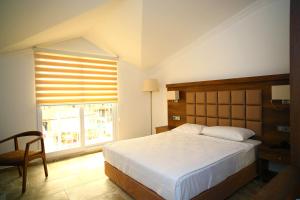 厄吕代尼兹Oludeniz Turquoise Hotel - All Inclusive的一间卧室设有一张大床和一个窗户。