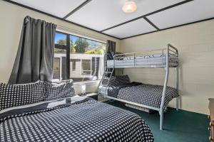 皮克顿Coastal Charm - Picton Holiday Home的带窗户的客房内的两张双层床