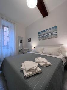 卡莫利LaMarina的一间卧室配有一张大床和毛巾