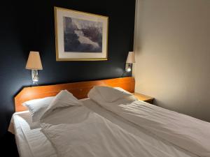 诺托登诺托登酒店的一间卧室配有带白色床单和枕头的床。