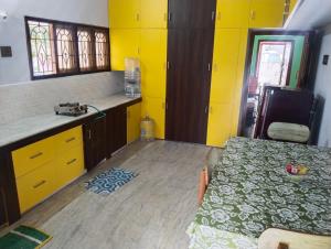 蒂鲁内尔维利Sharada Homestay的一间厨房,里面设有黄色的墙壁和一张桌子