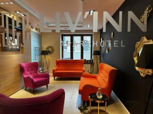 克拉科夫丽茵公寓式酒店的一间备有橙色和粉红色椅子的等候室