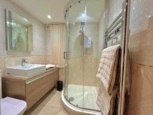 布雷肯Brecon serviced apartments- Kian Perrott Properties的一间带玻璃淋浴和水槽的浴室