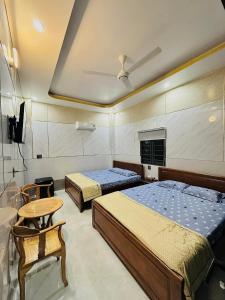 龙川市Golden Hotel的一间卧室配有两张床和一张桌子