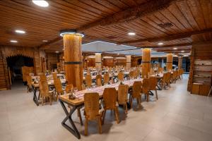 克利默内什蒂Complex Turistic Casa Romaneasca的大型用餐室配有桌椅