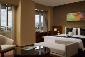 雅加达eL Hotel Jakarta的酒店客房带一张床、一张桌子和椅子